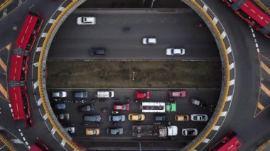 Bogota, Kolombiya, Latin Amerika 'daki Roundabout' ların insansız hava aracı görüntüleri. Bogota, Transmilenio 'da trafik vardı. En üst katta özel bir otobüs var. Kırmızı otobüslerle dolu ünlü bir döner kavşak. Yüksek kalite 4k görüntü.