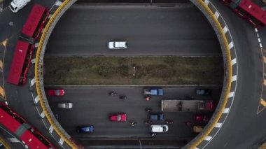 Bogota, Kolombiya, Latin Amerika 'daki Roundabout' ların insansız hava aracı görüntüleri. Bogota, Transmilenio 'da trafik vardı. En üst katta özel bir otobüs var. Kırmızı otobüslerle dolu ünlü bir döner kavşak. Yüksek kalite 4k görüntü.