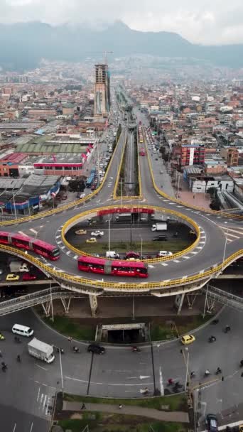 ボゴタ コロンビア ラテンアメリカのラウンドアバウトの航空無人機ショット ボゴタのトラフィック トランスミレニオ トップレベルにある専用バス 赤いバスでいっぱいの有名なラウンドアウト 高品質の4K映像 — ストック動画