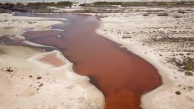 Salinas de Manaure veya Manaure tuz düzlükleri yakınlarındaki turuncu demir gölü gösteren hava aracı görüntüleri, Kuzey Kolombiya, Latin Amerika. Güzel kuzey Kolombiya doğası, turuncu göl ve çöl. 4K görüntü.