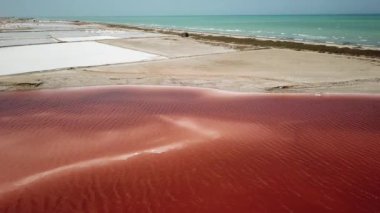 Salinas de Manaure veya Manaure tuz düzlüklerinin hava aracı görüntüleri, Kuzey Kolombiya, Latin Amerika. Güzel kuzey Kolombiya doğası, kızıl göl, tuz düzlüğü ve Karayip denizi. 4K görüntü.