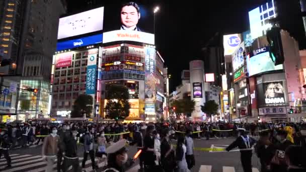 1月25日 24日 渋谷のスクランブル交差点を歩く日本人の群衆 日本の警察はハロウィーンの間に交通を指示しています 高品質の4K映像 — ストック動画