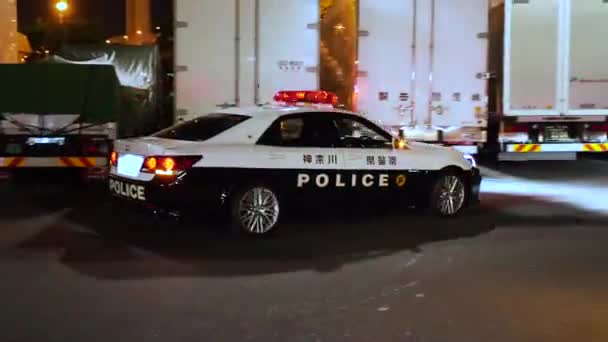 Japanilainen Poliisi Nousee Autoon Japanin Poliisiauto Ajovalot Päällä Poliisiauto Yöllä — kuvapankkivideo