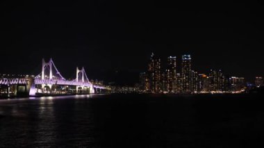 Güney Kore, Haeundae 'de gökdelenleri olan Busan' daki Gwangan veya Diamond Köprüsü gece görüşü. Yüksek kalite 4k görüntü