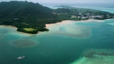 Japonya 'nın Okinawa bölgesindeki Ishigaki Adası' ndaki Kabira Körfezi 'nin insansız hava aracı görüntüleri. Turkuaz temiz su ve küçük yeşil adaları olan beyaz kumsal. Yüksek kalite 4k görüntü.