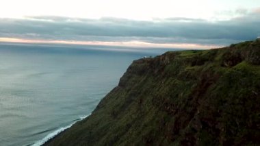 Portekiz 'in Atlantik Okyanusu' ndaki Madeira adasının gün batımında muhteşem bir hava aracı görüntüsü. Madeira Adası 'nın yeşil peleriniyle kaplı uçurumlar. Achadas da Cruz 'un hava manzarası. Yüksek kalite 4k görüntü