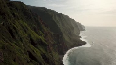 Portekiz 'in Madeira Adası' nda, gün batımında Santa Maria Madalena etrafındaki Ponta da Ladeira dağlarının üzerinden geçen insansız hava aracı görüntüleri. Kuzeybatı kısmı zirveler ve zirveler. Yüksek kalite 4k görüntü