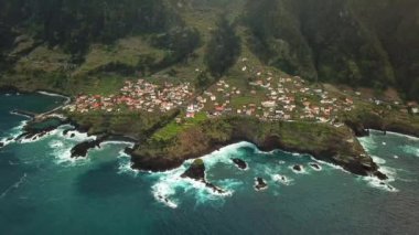 Portekiz 'in gün batımında Madeira Seixal köyünün nefes kesici bir dağ manzarasının insansız hava aracı görüntüleri. Yüksek kalite 4k görüntü