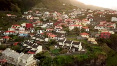 Portekiz 'in gün batımında Madeira Seixal köyünün nefes kesici bir dağ manzarasının insansız hava aracı görüntüleri. Yüksek kalite 4k görüntü