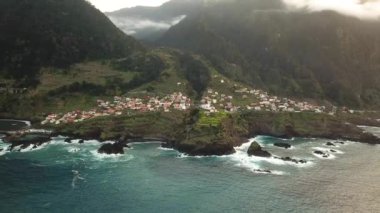 Portekiz 'in gün batımında Madeira Seixal köyünün nefes kesici bir dağ manzarasının insansız hava aracı görüntüleri. Yüksek kalite 4k görüntü