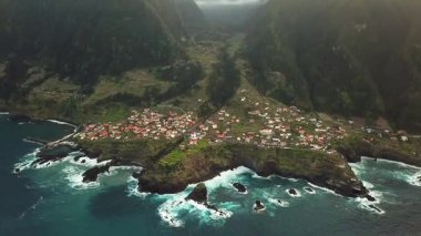 Portekiz 'in gün batımında Madeira Seixal köyünün nefes kesici bir dağ manzarasının insansız hava aracı görüntüleri. Yüksek kalite 4k görüntü