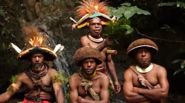 Tari, Papua Yeni Gine - 26 Mart, 25: Huli Wigmen Highland bölgesinin derinliklerinde küçük bir şelalenin yanında oturuyor. Kabile savaşçıları töreni. Papuan kabilesi dansı. Yüksek kalite 4k görüntü.