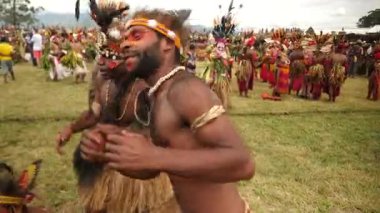 Hagen Dağı, Papua Yeni Gine - 26 Mart 25: Papuan kabile dansı. Hagen Dağı kabilesi festivali. Kültürel bir etkinlik. Yerli kostümlü yerli adamlar daireler çizerek dans ediyor. Yüksek kalite 4k görüntü.