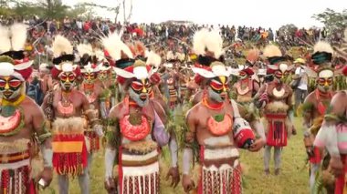 Hagen Dağı, Papua Yeni Gine - 26 Mart 25: Papuan kabile dansı. Hagen Dağı kabilesi festivali. Kültürel bir etkinlik. Yerli kostümlü yerli adamlar tek sıra halinde yürüyorlar. Yüksek kalite 4k görüntü.