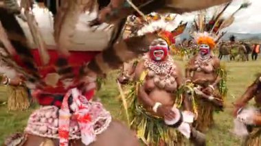 Hagen Dağı, Papua Yeni Gine - 26 Mart 25: Papuan kabile dansı. Hagen Dağı kabilesi festivali. Kültürel bir etkinlik. Yerli kadınlar ve erkek kostümleri içinde daireler çizerek dans ediyorlar. Yüksek kalite 4k görüntü.
