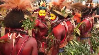 Hagen Dağı, Papua Yeni Gine - 26 Mart, 25 Mart, Huli Wigmen zıplama dansı. Hagen Dağı kabilesi festivali. Kültürel bir etkinlik. Yerli kostümlü yerli adamlar daireler çizerek dans ediyor. Yüksek kalite 4k görüntü.