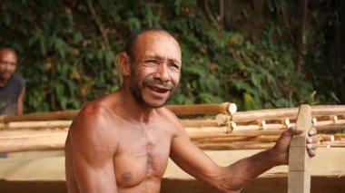 Goroka, Papua Yeni Gine - 26 Nisan, 25: Kırmızı dişli yerel papuan bir tekne yapıyor. Yüksek kalite 4k görüntü.