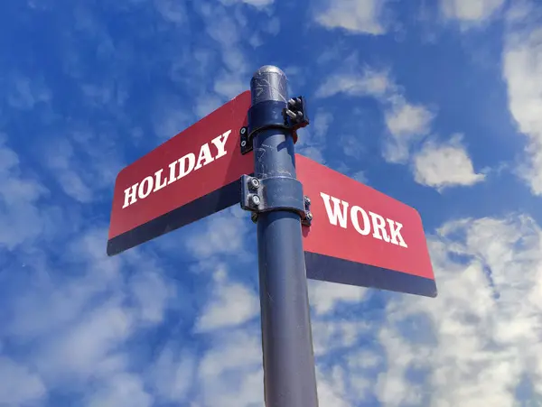 Holiday vs Work. White two street signs with arrow on metal pole with word. Directional road. Crossroads Road Sign, Two Arrow. Blue sky background. Two way road sign with text.