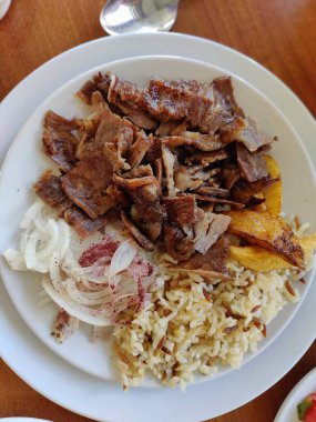 Otantik Lezzet: Aromatik Pirinç ve Tangy Soğan Garnitürüyle servis edilen Baharatlı Izgara Et. Türk lokantası, Kebap. 