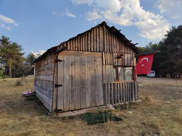 stock image Rural Resilience: A Rustic Cabin with the Turkish Flag, Symbolizing National Pride and Simplicity Amidst Nature's Embrace