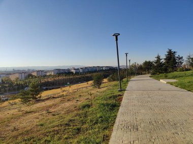 A serene pathway overlooking Ankaras urban landscape, where nature meets the horizon, offering a quiet escape from the city's hustle. clipart