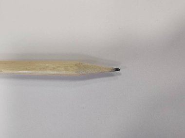 Basitliğin Doğruluğu: Keskinleştirilmiş bir kalem boş bir tuval üzerinde duruyor, yaratıcılığın potansiyelini sembolize ediyor, basit bir aracın derin fikirler ve hikayeler oluşturabileceği bir yer..