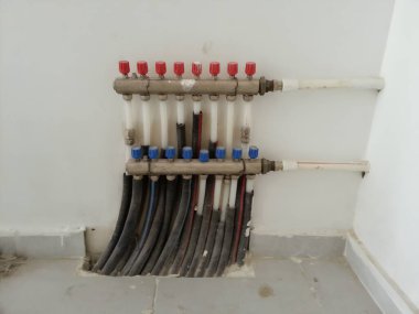 Yeraltı Isıtma Kılavuzu Sistemi Modern Bina İç Duvarı Kırmızı ve Mavi Kapakçık Düzenlemeleri 'ne boru ve valflerle kurulmuş