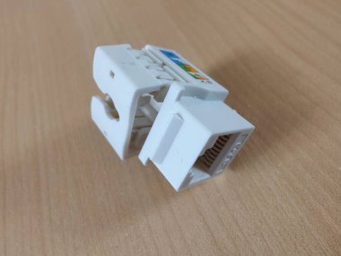 Beyaz RJ45 Ethernet Anahtar Taşı Jack 'in yakın planında Tahta Yüzey Üzerinde Renk Kodlu Kablo Diyagramı, Ağ ve Veri Kablosu İçin İdeal