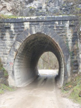 Taş Geçit 'in içinden Bilinmeyene çıkan, Dönüşümü, Dayanıklılığı ve Doğanın Ortasındaki Yeni Ufuklara Yolculuğu sembolize eden, Sonsuz Tünel Sessiz Kucaklaşır.