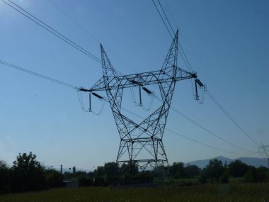 Açık Mavi Gökyüzüne Karşı Elektrik Sütunları Yükseliyor: Doğanın Huzuruyla Birleşmiş Endüstri Sembolü