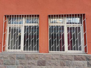 Turuncu Kısıtlama Duvarı: Izgara Pencereler, Katı Taş ve İnce Şehir İzolasyonu Fiziksel ve Duygusal Engeller İçin Bir İkilik Sembol.