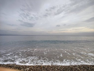 Sessiz Kıyı: Bitmeyen Ufuklar ve Geçici Dalgalar 'ın Metaforu, Çakıl Sessizliği' nin Dengesiz Güç ve Barış Dengesi 'ndeki Sessizliğin Ortasında Zamansız Sessizliği Yansıtarak Moody Gökyüzü' yle Buluştuğu Yer..