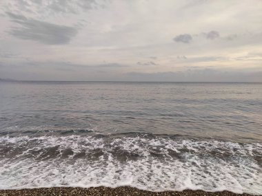 Sessiz Kıyı: Bitmeyen Ufuklar ve Geçici Dalgalar 'ın bir metaforu, Çakıl Sessizliği' nin Dengesiz Gökyüzü 'yle buluştuğu, Doğadaki Sessizliğin Ortasında Sessizliğin Ortasında Sessizliğin Yansıttığı,.