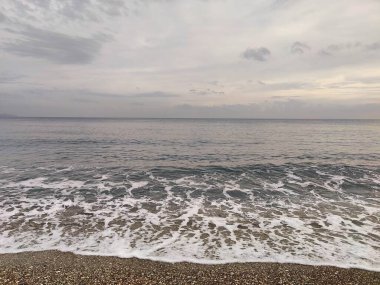 Sessiz Kıyı: Bitmeyen Ufuklar ve Geçici Dalgalar 'ın bir metaforu, Çakıl Sessizliği' nin Dengesiz Gökyüzü 'yle buluştuğu, Doğadaki Sessizliğin Ortasında Sessizliğin Ortasında Sessizliğin Yansıttığı,.