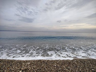 Sessiz Kıyı: Bitmeyen Ufuklar ve Geçici Dalgalar 'ın bir metaforu, Çakıl Sessizliği' nin Dengesiz Gökyüzü 'yle buluştuğu, Doğadaki Sessizliğin Ortasında Sessizliğin Ortasında Sessizliğin Yansıttığı,.