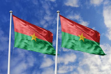 İki Burkina Faso bayrağı, ulusal gurur için bir metafor, mavi gökyüzüne karşı birlikte dalgalanıyor, birlik ve kültürel gücü simgeliyor..