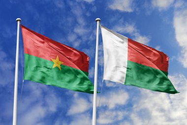 İki Burkina Faso bayrağı, ulusal gurur için bir metafor, mavi gökyüzüne karşı birlikte dalgalanıyor, birlik ve kültürel gücü simgeliyor..
