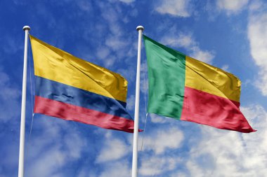 Kolombiya ve Benin 'in Bayrakları Parlak Mavi Gök Altında Birlikte Dalgalanıyor Diplomatik İlişkileri ve Küresel Bağlantıları simgeliyor.