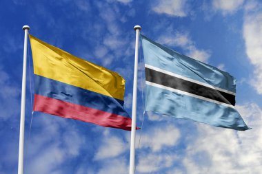 Kolombiya ve Botswana Bayrakları Parlak Mavi Gökyüzüne Karşı Birlikte Dalgalanıyor Diplomatik İlişkiler ve Küresel Ortaklığı simgeliyor.