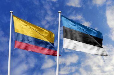 Kolombiya ve Estonya bayrakları, uluslararası dostluğu, diplomatik bağlantıları ve küresel çeşitliliğin birliğini simgeleyen açık mavi gökyüzüne gururla sergileniyor..