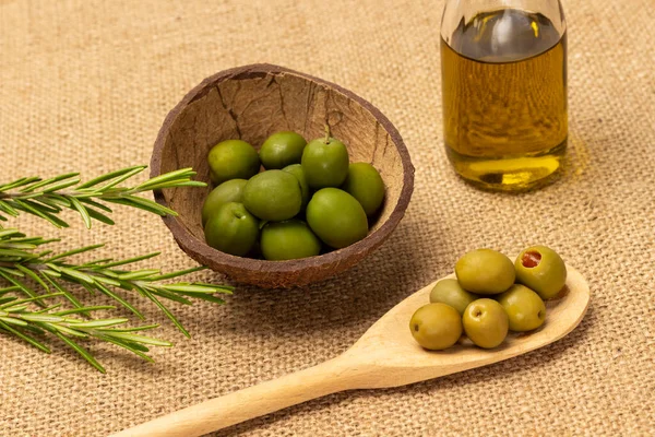 Green Olives Wooden Spoon Coconut Shell Olive Oil Bottle Sprig — Stock Photo, Image