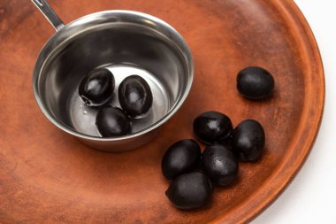 Black olives on a ceramic plate and in a metal bowl. Top view.