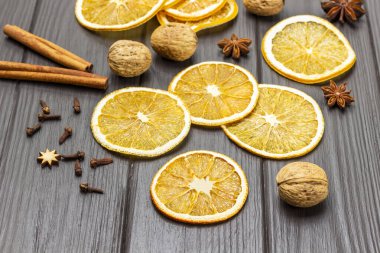 Kuru portakal dilimleri, ceviz ve tarçın çubukları. Üst Manzara. Koyu tahta arkaplan.