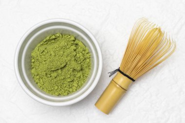 Kasede yeşil kibrit tozu. Çaça çayı yapmak için Chasen çırpıcı. Düz yatıyordu. Beyaz arkaplan