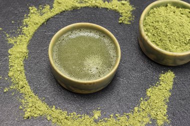 Bir kase kibrit tozu ve bir kase kibrit çayı. Masada kibrit tozu var. Üst Manzara. Siyah arkaplan