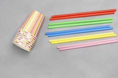 Tek kullanımlık plastik sofra takımı. Tabak, kaşık, çatal ve pipet. Plastik işleme sorunu. Ekoloji çevresel bakım. Düz yatıyordu. Gri arkaplan