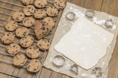 Hazır kurabiyeler. Kağıt üzerinde kurabiye pişirmek için gübre. Kurabiye kalıpları. Noel pastanesi. Ahşap arka plan. Üst görünüm