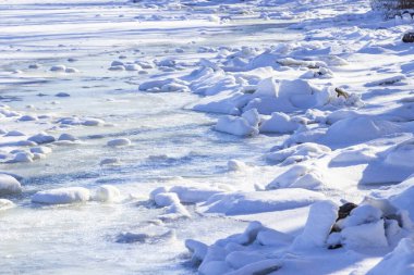 Nehir kıyısında karla kaplı buz parçaları. Donmuş nehir.