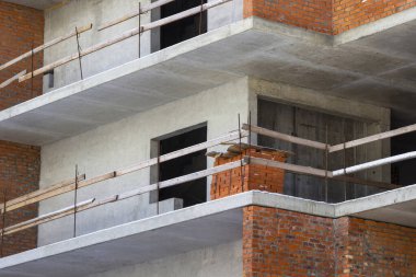 Bitmemiş bir evin beton zemininde seramik tuğlalar yığını. Çerçevenin bir parçası