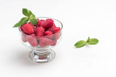 Cam kasede olgun ahududu. Nane yaprakları ve böğürtlen masada. Uzayı kopyala Beyaz arka plan. Üst görünüm